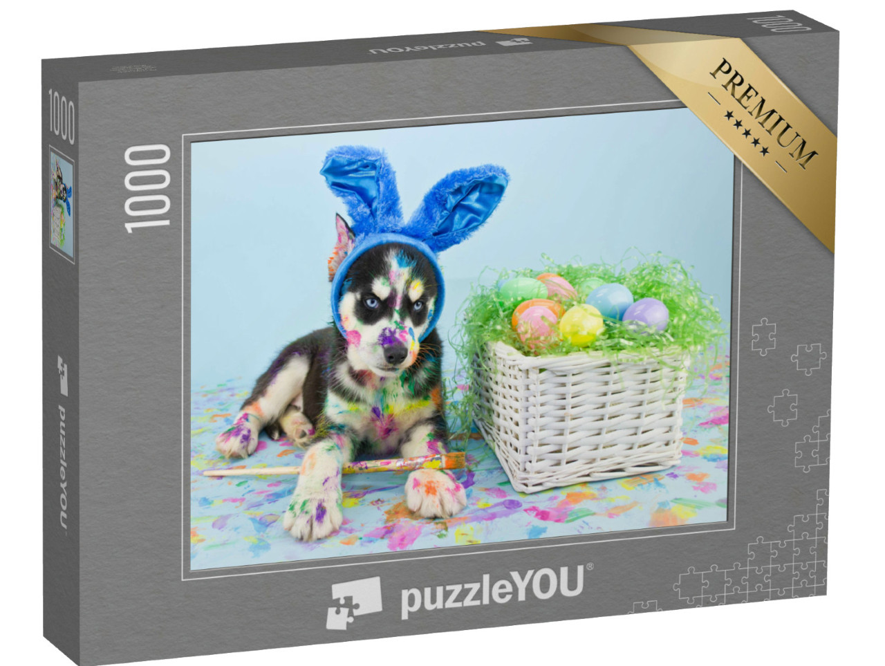 Puzzle 1000 Teile „Ein Husky-Welpe mit blauen Osterhasenohren beim Eier bemalen“