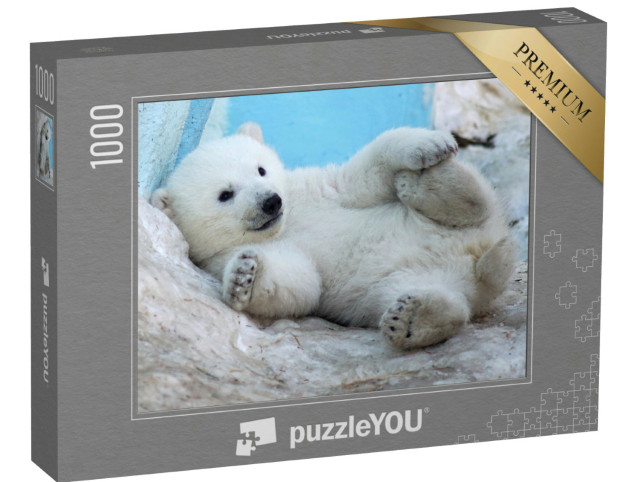 Puzzle 1000 Teile „Ein Eisbärenjunges liegt auf dem Rücken im Schnee“