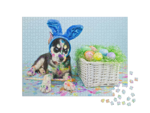Puzzle 1000 Teile „Ein Husky-Welpe mit blauen Osterhasenohren beim Eier bemalen“