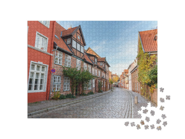 Puzzle 1000 Teile „Straße mit mittelalterlichen alten Backsteinbauten, Lüneburg, Deutschland“