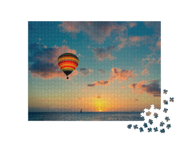 Puzzle 1000 Teile „Heißluftballon über dem Meer bei Sonnenuntergang“