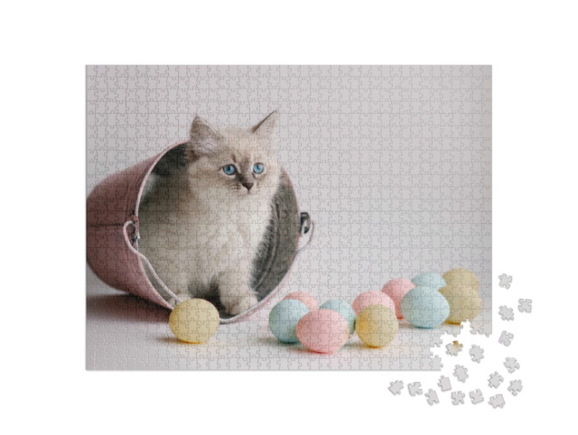 Puzzle 1000 Teile „Eine Katze im Eimer mit bunten Ostereiern“