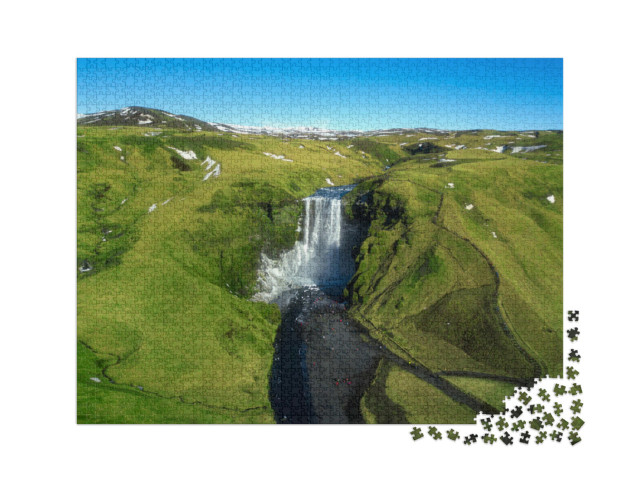 Puzzle 2000 Teile „Berühmte Wasserfälle: Skogafoss mitten in Island, Luftansicht“