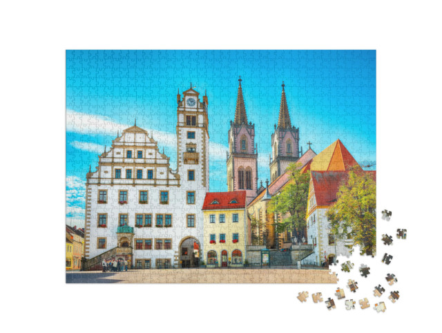 Puzzle 1000 Teile „Stadtbild des Oschatzer Hauptplatzes mit Stadtverwaltung und St. Aegidien, Sachsen“