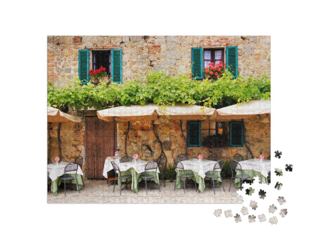 Puzzle 1000 Teile „Café-Tische und Stühle vor einem malerischen Steingebäude in der Toskana, Italien“